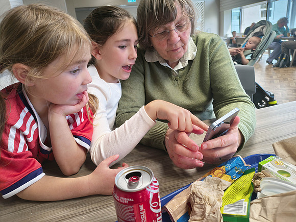 Norah, Margot and Ann looking at mobile phone